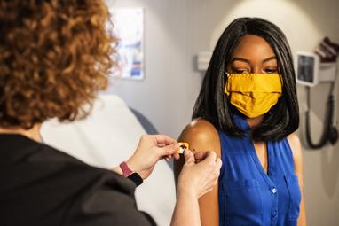 Une femme reçoit un sparadrap du docteur